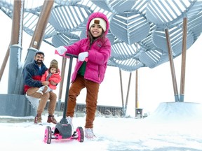 Jeff D'Silva with his daughters Story, 2, and River D'Silva, 4, on her scooter at the skateboard park in Carrington.