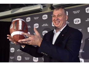 Randy Ambrosie tosses a football as he speaks during a press conference in Toronto on July 5, 2017. The CFL commissioner said Friday he'll be meeting football officials from Germany later this month to discuss the possibility of Canadian and German players suiting up in the respective circuits.