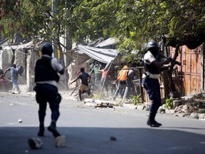 National police shoot at protesters demanding the resignation of Haitian President Jovenel Moise near the presidential palace in Port-au-Prince, Haiti, Wednesday, Feb. 13, 2019. Protesters are angry about skyrocketing inflation and the government's failure to prosecute embezzlement from a multi-billion Venezuelan program that sent discounted oil to Haiti.