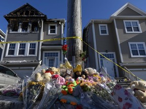 A memorial of flowers and stuffed animal toys is seen outside the scene of a fatal house fire in the Spryfield community in Halifax on Wednesday, February 20, 2019.