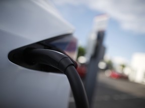 A 2018 Model X is plugged into a charging station at a Tesla dealership in Littleton, Colo. Cold temperatures can sap electric car batteries, temporarily reducing their range by more than 40 percent when interior heaters are used, a new study by the AAA has found.