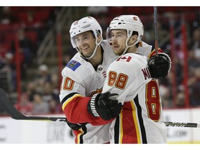 Calgary Flames' Derek Ryan (10) is congratulated by Andrew Mangiapane (88) after his goal against the Carolina Hurricanes during the second period of an NHL hockey game in Raleigh, N.C., Sunday, Feb. 3, 2019.