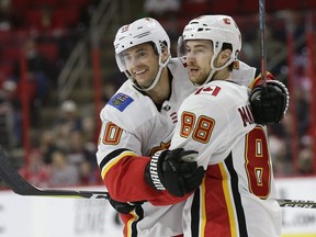 Calgary Flames' Derek Ryan (10) is congratulated by Andrew Mangiapane (88) after his goal against the Carolina Hurricanes during the second period of an NHL hockey game in Raleigh, N.C., Sunday, Feb. 3, 2019. (AP Photo/Gerry Broome) ORG XMIT: NCGB111