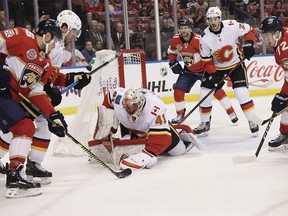 Calgary Flames goaltender Mike Smith catches the puck in front of Florida Panthers center Aleksander Barkov during the first period of an NHL hockey game Thursday, Feb. 14, 2019, in Sunrise, Fla. (AP Photo/Brynn Anderson) ORG XMIT: FLBA105