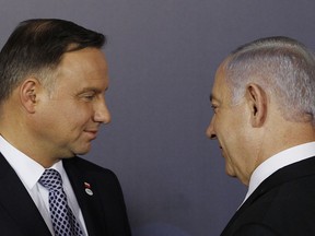FILE - In this Wednesday, Feb. 13, 2019 file photo, Polish President Andrzej Duda , left, and Israeli Prime Minister Benjamin Netanyahu, talk after a group photo during a two-day international conference on the Middle East, at the Royal Castle in Warsaw, Poland. An off-hand comment by Netanyahu in Warsaw about Poland and the Holocaust looks to overshadow a summit of central European leaders this week in Israel. Poland's abrupt decision Sunday to downgrade its participation in the Visegrad conference suddenly cast a pall gathering.