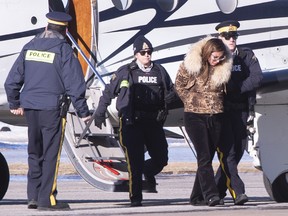 RCMP officers escort a suspect arrested in a money laundering network off an airplane in St-Hubert, Que. on Monday, February 11, 2019. The RCMP and other police forces arrested 15 people Monday in a series of raids in Montreal and Toronto targeting what investigators say is an extensive international money laundering network with ties to organized crime.