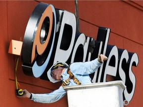 A crane operator installs a Payless Shoesource sign to the front of the store Thursday afternoon, Jan. 19, 2012, on Range Line Road in Joplin, Mo. Payless ShoeSource Canada Inc. says it will soon file for creditor protection in Canada and close all 2,500 of its North American stores this spring.