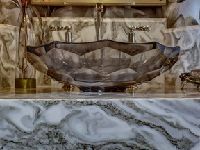 A mid-century style faceted glass sink by Kohler is a centrepiece in a powder room renovation by interior designer Kerri-Anne Thomas.
