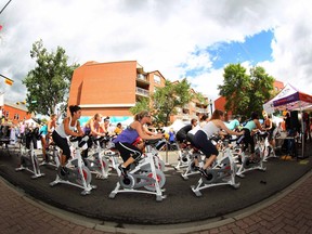 Spin enthusiasts work on in a display in front of YYC Cycle on Kensington Road. YYC Cycle will be opening a new location in University District.