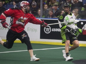 Calgary Roughnecks defender Tyler Burton goes to attack Rush transition Jeremy Thompson during the game last night at SaskTel Centre in Saskatoon. Photo by Kayle Neis/Postmedia.