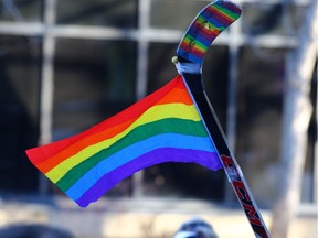 A rainbow flag adorning a hockey stick waves above a 2017 rally at Calgary's McDougall Centre in support of gay-straight alliances.