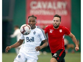 Whitecaps Georges Mukumbilwa (left) and Cavalry FC Sergio Camargo eye the ball during an exhibition game between the Vancouver Whitecaps U23 and Cavalry FC at the Foothills Fieldhouse in Calgary on Tuesday. Cavalry won 2-0. Photo by Jim Wells/Postmedia.