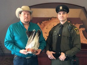Kent Ayoungman, a member of the Siksika Nation who handles re-appropriated ceremonial items, and Fish and Wildlife Enforcement Officer Philip Marasco are seen in an undated handout photo with the missing headdress.