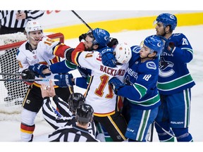 Calgary Flames' Matthew Tkachuk (19) and Mikael Backlund (11), of Sweden, get into a scuffle with Vancouver Canucks' Erik Gudbranson (44), and Jake Virtanen (18) as Brandon Sutter (20) watches during second period NHL hockey action in Vancouver on Saturday, Feb. 9, 2019.