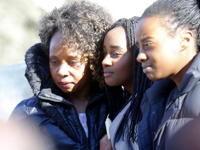 Gladys Kivia and her children attend a vigil at city hall on Sunday for her husband, Derick Lwugi, a city accountant who was among 18 Canadians killed in last weekend's Ethiopian Airlines crash.