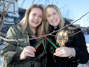 L-R, Mahogany Angels, Lindsay Anderton and Jamie Baietto were tying ribbons on the trees in the community of Mahogany to support and raise funds for Derick Lwugi, an accountant with the City of Calgary who died in the Ethiopia plane crash in Calgary on Wednesday March 13, 2019. Darren Makowichuk/Postmedia