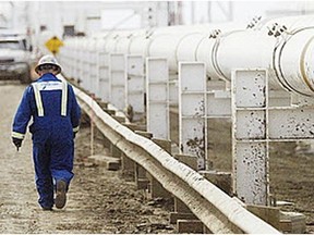 A worker walks along a new pipeline at the Enbridge facility in the east of Edmonton.