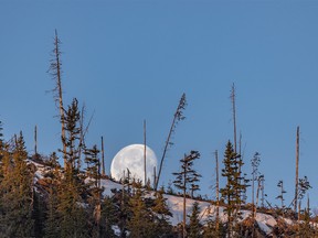 The moon sets behind a ridge above Sibbald Flats west of Calgary on Monday, April 22, 2019. Mike Drew/Postmedia