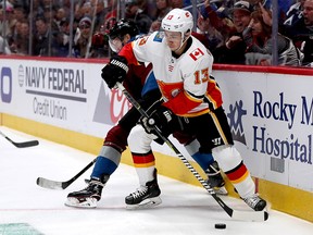 DENVER, COLORADO - APRIL 15: Johnny Gaudreau #13 of the Calgary Flames fights on the boards with Carl Soderberg #34 of the Colorado Avalanche in the first period during Game Three of the Western Conference First Round during the 2019 NHL Stanley Cup Playoffs at the Pepsi Center on April 15, 2019 in Denver, Colorado. (Photo by Matthew Stockman/Getty Images)