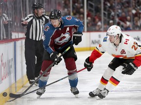 DENVER, COLORADO - APRIL 17: Erik Johnson #6 of the Colorado Avalanche fights for the puck against Sean Monahan #23 of the Calgary Flames in overtime during Game Four of the Western Conference First Round during the 2019 NHL Stanley Cup Playoffs at the Pepsi Center on April 17, 2019 in Denver, Colorado. (Photo by Matthew Stockman/Getty Images)