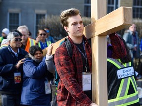 Dawson Warman carries the cross during St. Mary's Cathedral's outdoor Way of the Cross procession in Calgary on Friday, April 19, 2019. Around one thousand people participated in this annual event. (Azin Ghaffari / Postmedia)