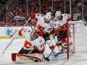 NEWARK, NEW JERSEY - FEBRUARY 27: David Rittich #33, Noah Hanifin #55 and Travis Hamonic #24 of the Calgary Flames block the net against the New Jersey Devils during the second period  at the Prudential Center on February 27, 2019 in Newark, New Jersey. (Photo by Bruce Bennett/Getty Images)