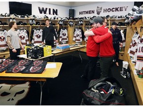 Calgary Hitmen VP Mike Moore hugs player Luke Coleman during the team's locker cleanout day at the Scotiabank Saddledome on Thursday. Photo by Gavin Young/Postmedia.