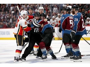 DENVER, COLORADO - APRIL 15: Matt Calvert #11 of the Colorado Avalanche fights Sam Bennett #93 ot the Calgary Flames in the third period during Game Three of the Western Conference First Round during the 2019 NHL Stanley Cup Playoffs at the Pepsi Center on April 15, 2019 in Denver, Colorado.