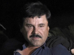 This file photo taken on Jan. 08, 2016 shows drug kingpin Joaquin "El Chapo" Guzman escorted into a helicopter at Mexico City's airport following his recapture during an intense military operation in Los Mochis, in Sinaloa State.