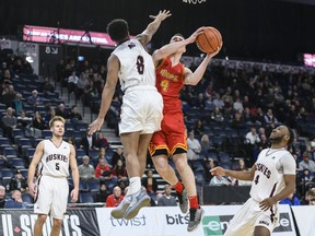 Calgary Dinos' Andrew Milner, second from right, leaps to put up a shot in front of Saint Mary's Huskies' Nevell Provo during the second half of quarterfinal action in the USports men's basketball national championship in Halifax on Friday, March 8, 2019.