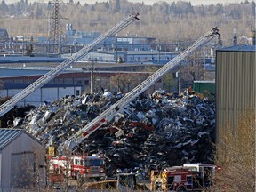 Two Calgary Fire Department aerial trucks watch over the scene of an early morning fire at a Calgary metal yard that was quickly put out on Wednesday April 24, 2019. Gavin Young/Postmedia