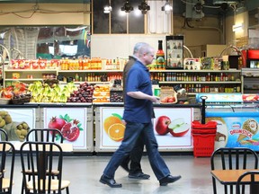 Customers walk in front of a grocery outlet at Eau Claire Market in downtown Calgary is shown on Friday, April 12, 2019. The redevelopment of the Eau Claire area, which became part of Calgary in 1886 when a Wisconsin-based lumber company set up a sawmill on the banks of the Bow River, has been a topic of discussion for decades. Advocates say the areaÕs proximity to the river, PrinceÕs Island Park and the pathway system gives it the potential to be the Òcrown jewelÓ of CalgaryÕs downtown Ñ however, it has never quite worked out that way. Jim Wells/Postmedia