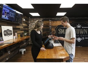 Nicole Felgate helps a customer with a cannabis product at Small Town Buds in Devon Alta, on Wednesday April 17, 2019.