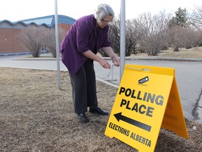Polling officer Alexandra Dubrovna puts out a sign for the advance poll in the riding of Calgary-Currie on April 19, 2012. Advance polls for the 2019 provincial election run Tuesday to Saturday.