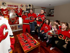 From left, Flames enthusiast Dean McCord celebrates with friends Joel Barnett, Art Judson, Nicole Judson, Brenda Mason, 4-year-old Dawnis George and 11-year-old Ashley Judson in his NW home turned into a Calgary Flames shrine. Sunday, April 7, 2019. Brendan Miller/Postmedia
