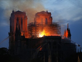 Firefighters tackle the blaze as flames and smoke rise from Notre Dame Cathedral as it burns in Paris, Monday, April 15, 2019.