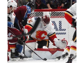 Calgary Flames goaltender Mike Smith, right, makes a stop of a shot by Colorado Avalanche left wing Gabriel Landeskog in the second period of Game 3 of a first-round NHL hockey playoff series, Monday, April 15, 2019, in Denver.