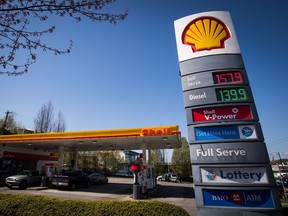 The price of a litre of gasoline of $1.579 is displayed on a sign as motorists fuel up at a Shell gas station in Vancouver, B.C., on Sunday April 22, 2018.