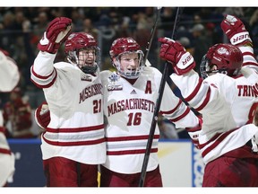 Massachusetts' Mitchell Chaffee (21) and Cale Makar (16) celebrate a goal against Denver during the first period in a semifinal of the Frozen Four NCAA men's college hockey tournament Thursday, April 11, 2019, in Buffalo, N.Y.