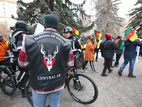 A man wearing a Soldiers of Odin vest watches a peaceful march in downtown Calgary on Dec. 15, 2018.