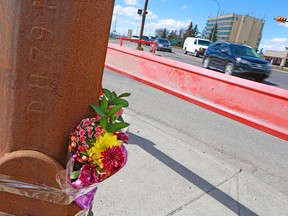 A bouquet of flowers is taped to a light post at 32nd Avenue and 26th Street N.E., one day after a pedestrian was killed on Monday, April 22, 2018.