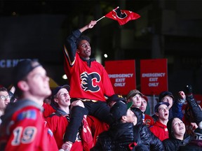 Flames fans react to the action on a giant outdoor TV as thousands join the C of Red to watch Game 5 at the “Red Lot” community viewing party outside the Dome. Friday, April 19, 2019.
