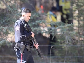 A Calgary police officer searches an area near the Fullerton Loop Hiking Trail on Highway 66 west of Bragg Creek on Friday, April 26, 2019, for signs of Jasmine Lovett and her daughter Aliyah Sanderson. The two were last seen in Cranston on April 16.