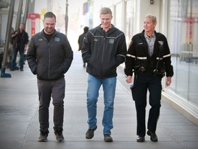 Adam Melnyk, and Alex Harris from Calgary Alpha House walk with Calgary Peace Officer  Katty Aalders on the CTrain platform near city hall in downtown Calgary. Wednesday, April 24, 2019. Dean Pilling/Postmedia