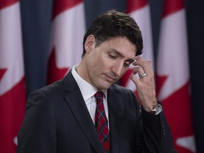 Canadian Prime Minister Justin Trudeau scratches his forehead as he listens to a question during an end of session news conference in Ottawa, Wednesday, Dec. 19, 2018.