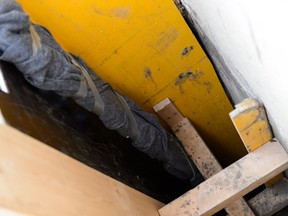 A makeshift ladder built by firefighters rises out of a shored up sinkhole housing at least one stray cat near a home near 87 Avenue and 67 Street on April 19, 2019.