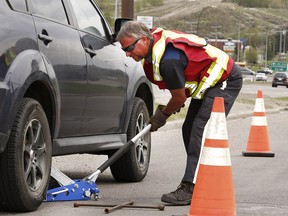 Neal Joad has been an operator with AMA for over 17 years. Joad is pictured working on a vehicle along Blackfoot Trail. Today is the first designated National Slow Down and Move Over Day that raises awareness operators and first responders who work along the side of the road. Tuesday, May 14, 2019. Brendan Miller/Postmedia