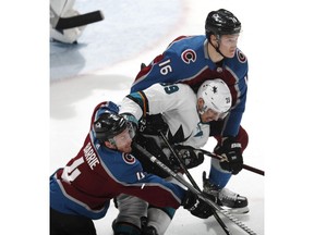 San Jose Sharks center Logan Couture, center, is sandwiched by Colorado Avalanche defensemen Tyson Barrie, bottom, and Nikita Zadorov during the third period of Game 4 of an NHL hockey second-round playoff series Thursday, May 2, 2019, in Denver. The Avalanche won 3-0.