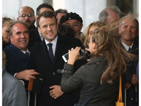 French President Emmanuel Macron poses for photos with supporters in Biarritz, southwestern France, Friday, May 17, 2019.