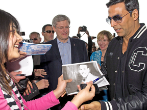 A fan asks Bollywood star Akshay Kumar for an autograph as he arrives with Prime Minister Stephen Harper and wife Laureen at a campaign event in Brampton, Ont., on Friday, April 8, 2011.